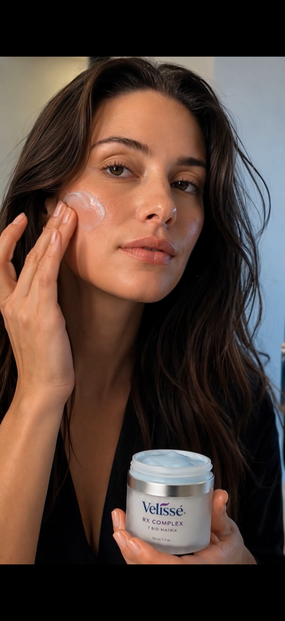 Model applying Velissé RX Complex to skin